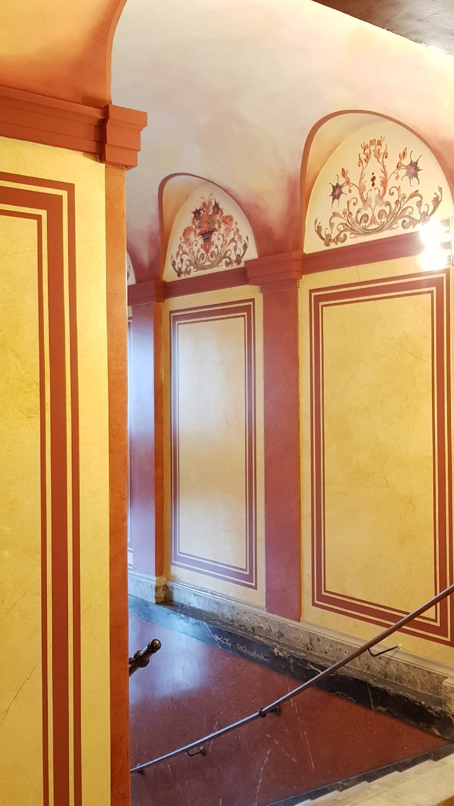 Fertiges Vestibül durch das Unternehmen Restaurierung und Gestaltung. Es wurden Malerarbeiten, Wandgestaltung, Deckengestaltung, Gestaltung des Himmels als Deckenmalerei, Marmorimitation bzw. Marmorierung am Entree sind fertiggestellt. Das Denkmal stellt sich in voller Pracht da. Dem Restaurator, Maler und Malermeister ist es gelungen den Formenzusammenhang am Denkmal in Charlottenburg zwischen Fassade und Treppenhaus wieder herzustellen. Hierzu gehören Malerarbeiten von hoher Qualität, Untersuchungen am Denkmal, klassischen Malereien wie Deckenmalerei, Holzimitation, Marmormalerei vor. Als Malerbetrieb und Restaurator hat sich der Maler und Restaurierungsbetrieb auf  hochwertige und exklusive Malerarbeiten spezialisiert. Oft werden von uns Treppenhäuser im Altbau komplett überarbeitet. Aber auch Untersuchungen und Konzepte am Denkmal bieten wir im Komplettpaket an.